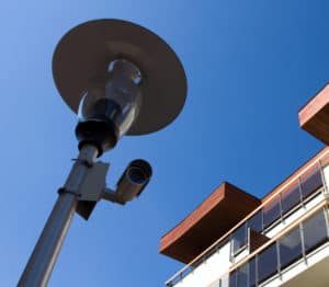 A sleek security camera attached to a lamppost is depicted.